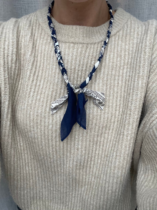 Sfeerfoto van donkerblauwe bandana ketting met zilveren bedels en beige trui